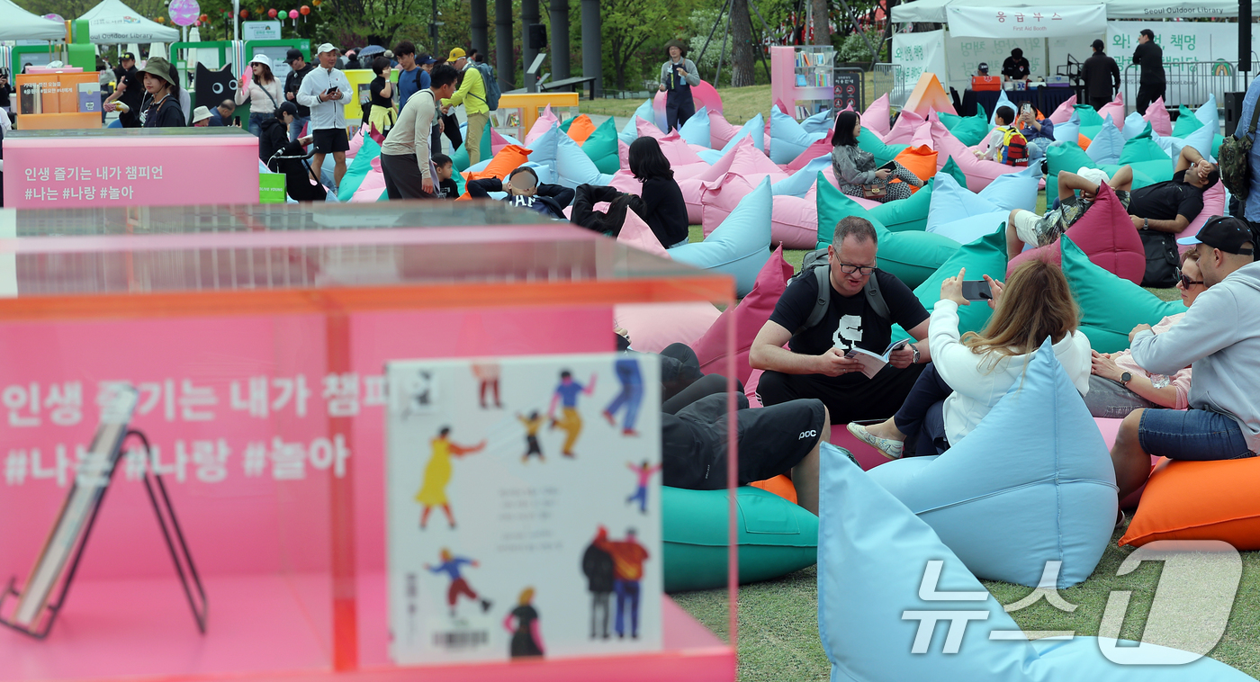 (서울=뉴스1) 박정호 기자 = 포근한 날씨를 보인 27일 서울 광화문 광장에 마련된 서울야외도서관 광화문책마당을 찾은 외국인 등이 여유로운 시간을 보내고 있다. 2025.4.27 …