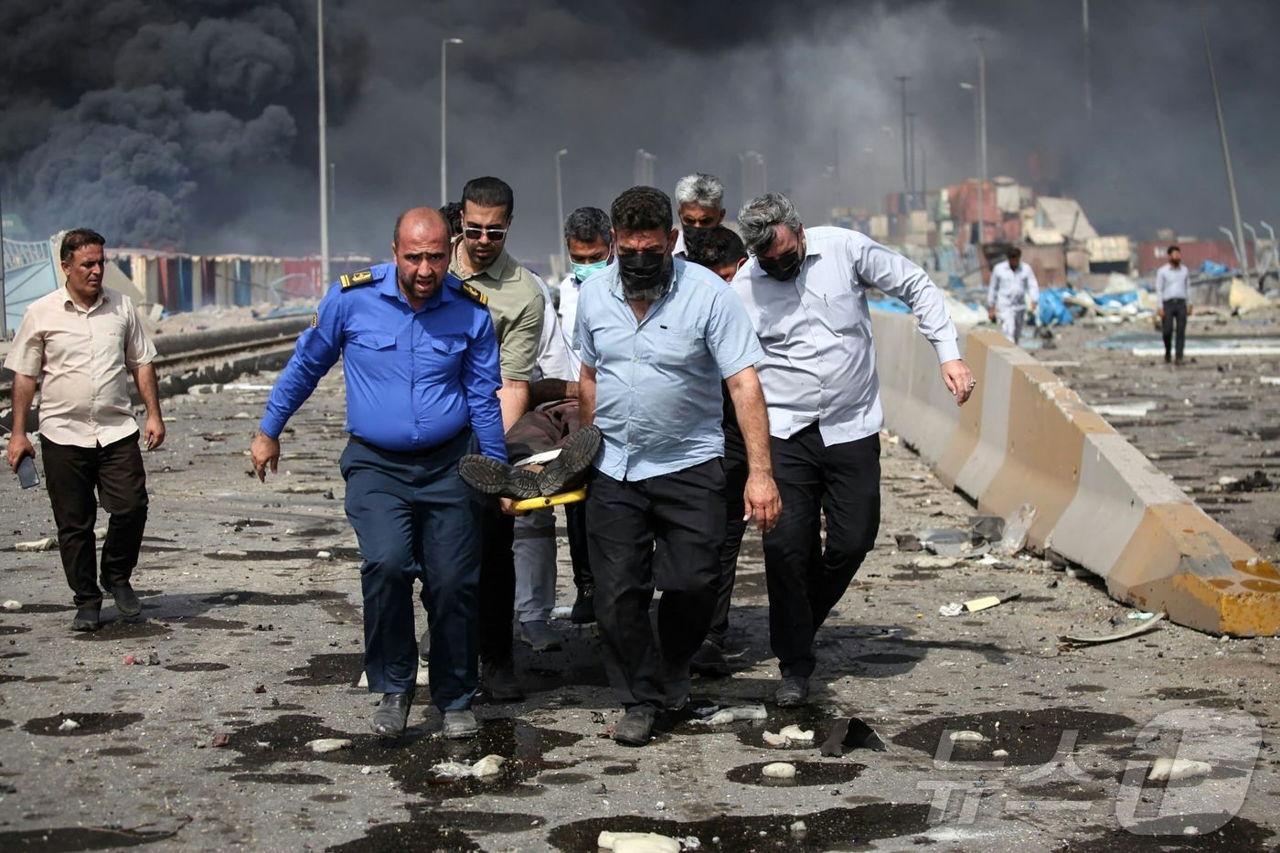 본문 이미지 - 26일(현지시간) 이란 남부 반다르아바스에 위치한 샤히드 라자이 항에서 대규모 폭발이 일었다. 시민들이 다친 부상자를 이송하는 모습. 25.04.26 ⓒ AFP=뉴스1 ⓒ News1 김예슬 기자