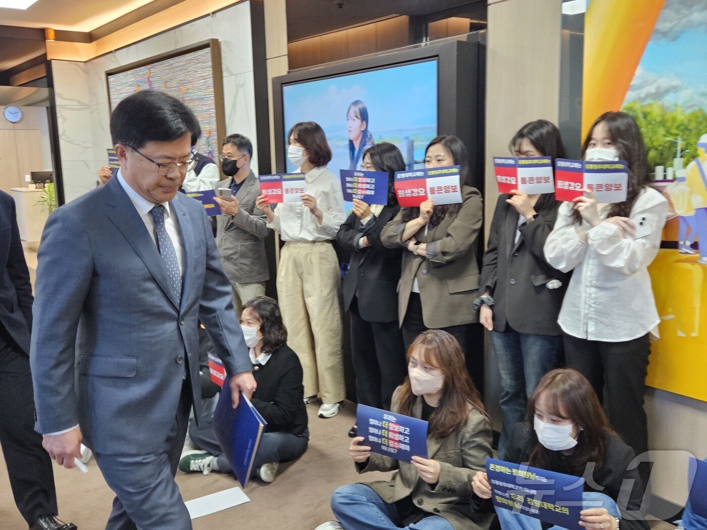 본문 이미지 - 정재연 강원대학교 총장이 28일 강원대 춘천캠퍼스 대학본부 3층 교무회의실에서 열리는 평의원회에 참석하기 위해 발걸음을 옮기고 있다. 이날 교직원들은 복도 앞에서 &#39;강원대-강릉원주대&#39; 통폐합 수정안에 반대하는 피켓을 들고 있었다. 2025.4.28/뉴스1 ⓒ News1 한귀섭 기자