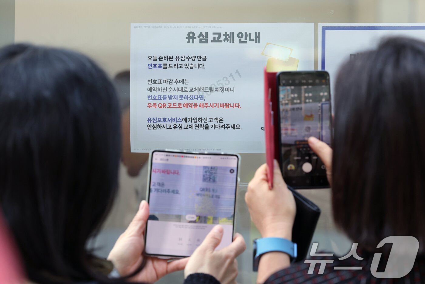 본문 이미지 - 해킹 공격으로 가입자 유심 정보가 탈취된 SK텔레콤이 가입자 유심 무상 교체를 시작한 28일 오전 서울 종로구 T월드 직영매장 앞에서 번호표를 받지 못한 고객들이 온라인 예약을 하고 있다. 2025.4.28/뉴스1 ⓒ News1 박정호 기자