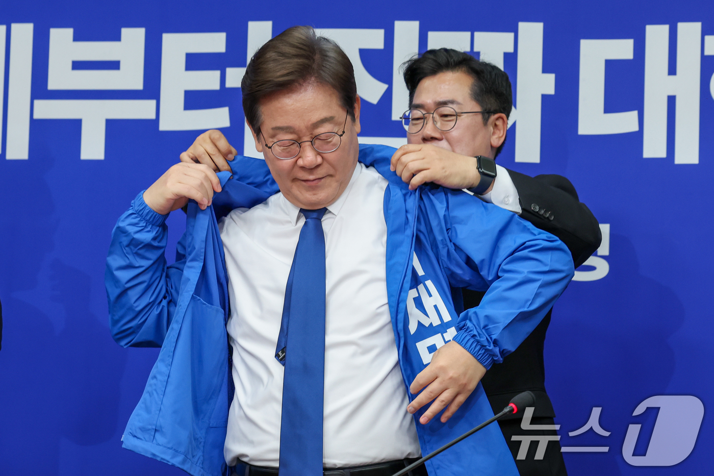 (서울=뉴스1) 안은나 기자 = 박찬대 더불어민주당 대표 직무대행 겸 원내대표가 28일 서울 여의도 국회에서 열린 최고위원회의에서 이재명 대선 후보에게 선거복을 입혀주고 있다. 2 …