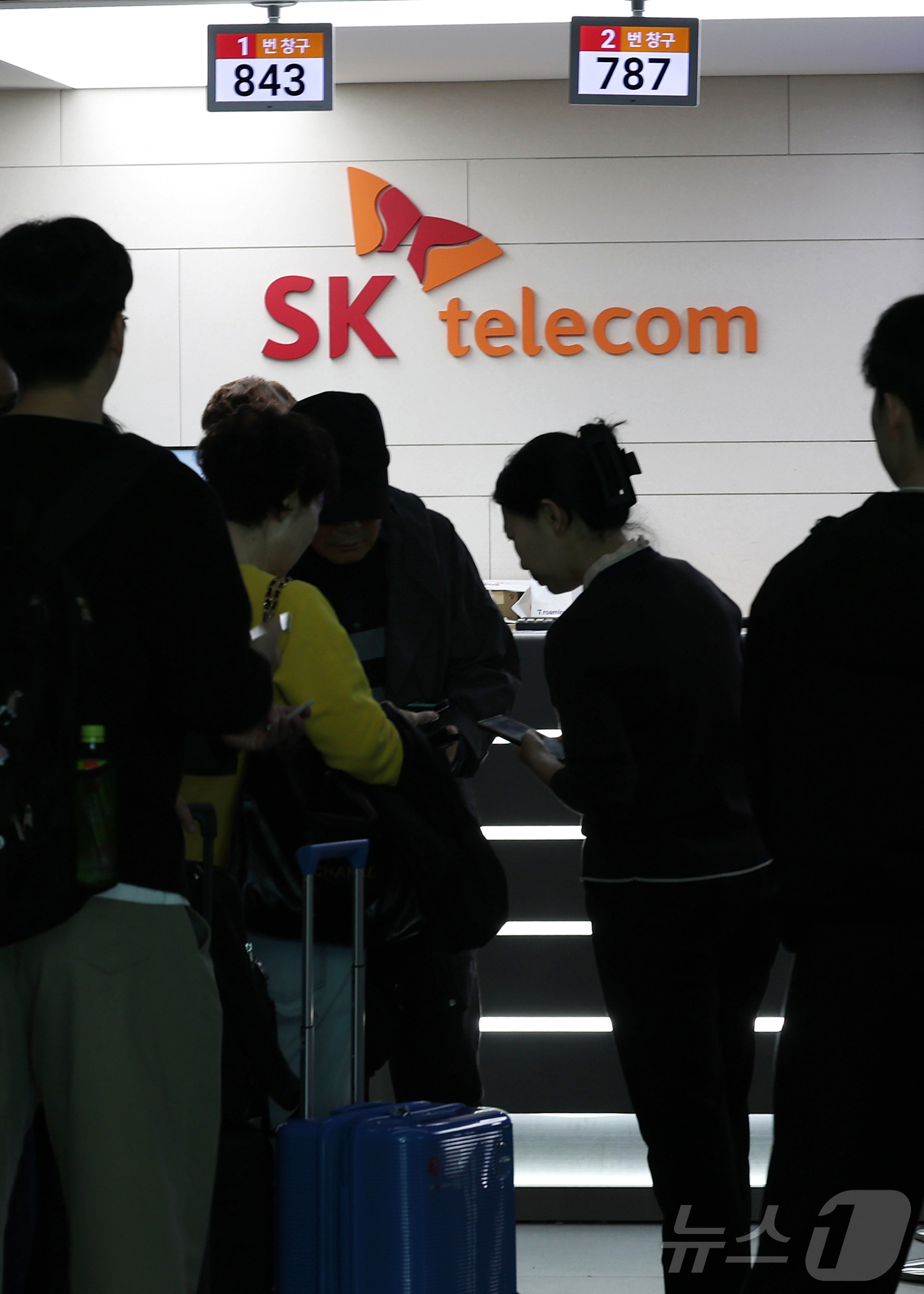 (인천공항=뉴스1) 권현진 기자 = 해킹 공격으로 가입자 유심 정보가 탈취된 SK텔레콤이 가입자 유심 무상 교체를 시작한 28일 오전 인천공항 제2터미널 SKT매장 앞에 고객들이 …