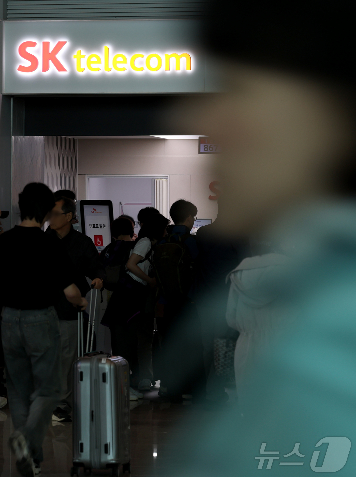 (인천공항=뉴스1) 권현진 기자 = 해킹 공격으로 가입자 유심 정보가 탈취된 SK텔레콤이 가입자 유심 무상 교체를 시작한 28일 오전 인천공항 제2터미널 SKT매장 앞에 고객들이 …