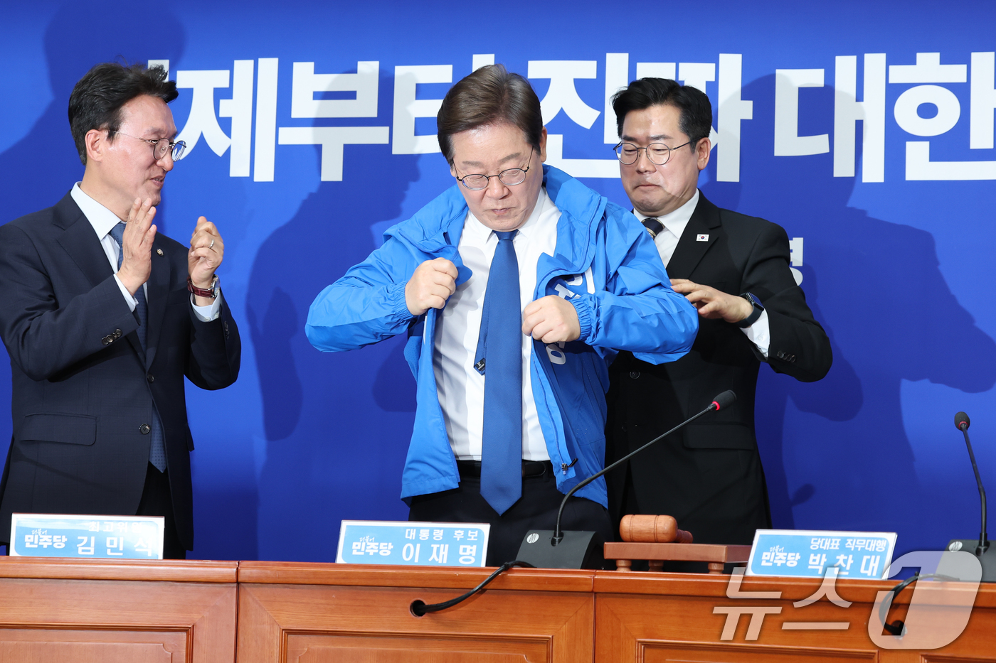 (서울=뉴스1) 안은나 기자 = 박찬대 더불어민주당 대표 직무대행 겸 원내대표가 28일 서울 여의도 국회에서 열린 최고위원회의에서 이재명 대선 후보에게 선거복을 입혀주고 있다. 2 …