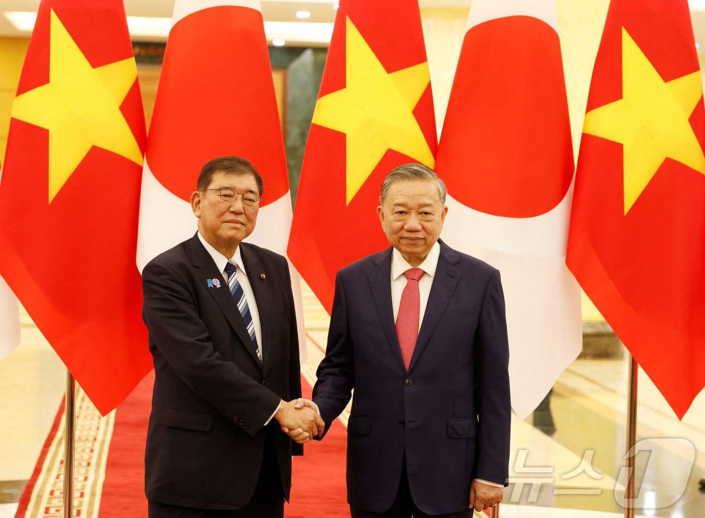 (하노이 AFP=뉴스1) 우동명 기자 = 이시바 시게루 일본 총리가 27일(현지시간) 동남아 순방 중 하노이에서 또 럼 베트남 공산당 서기장과 만나 악수를 하고 있다. 2025.0 …