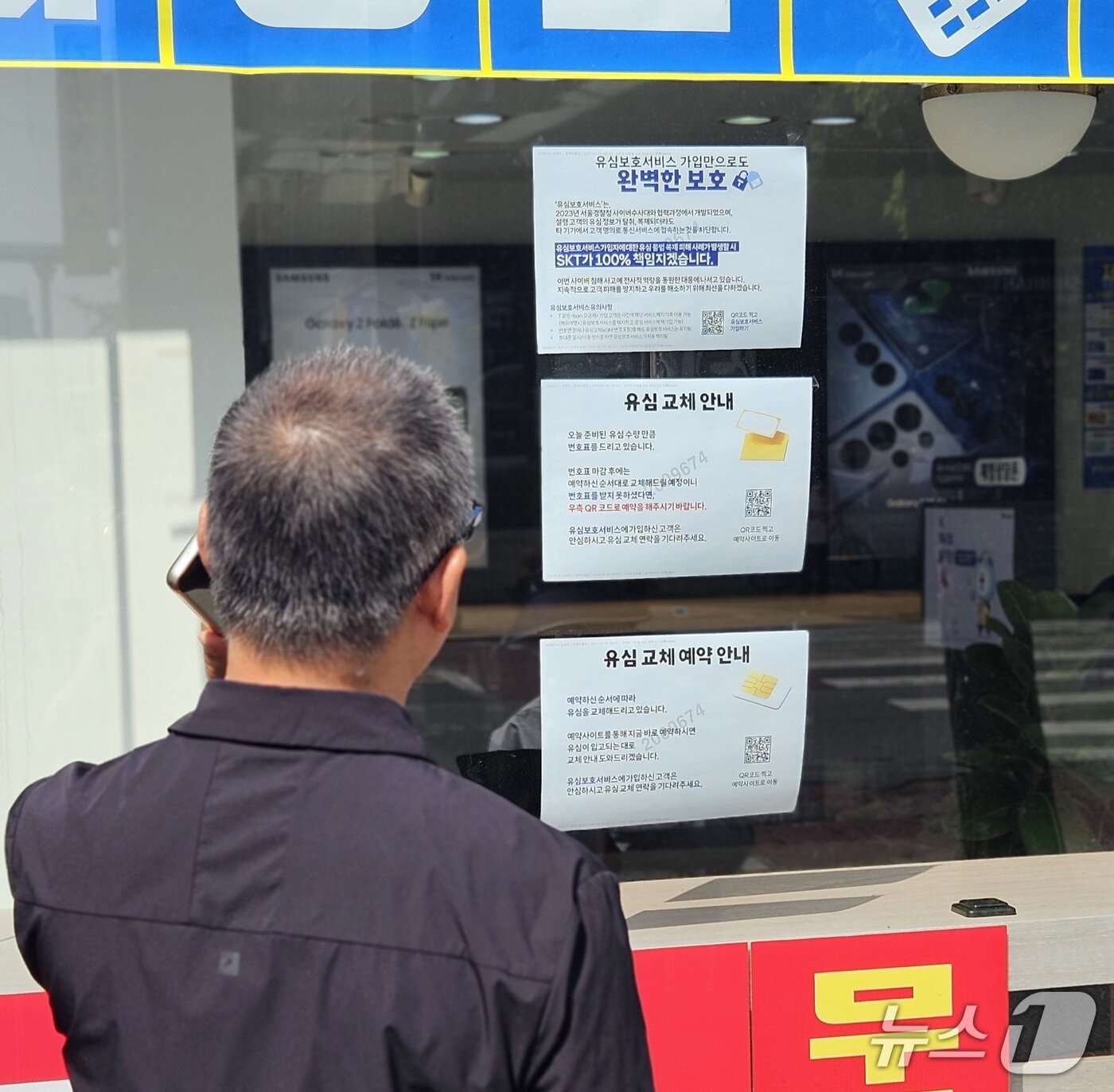 본문 이미지 - 28일 전북자치도 전주시의 한 SK텔레콤 대리점에서 한 시민이 유심 무상 교체 안내문을 읽고 있다. /뉴스1 신준수 기자  