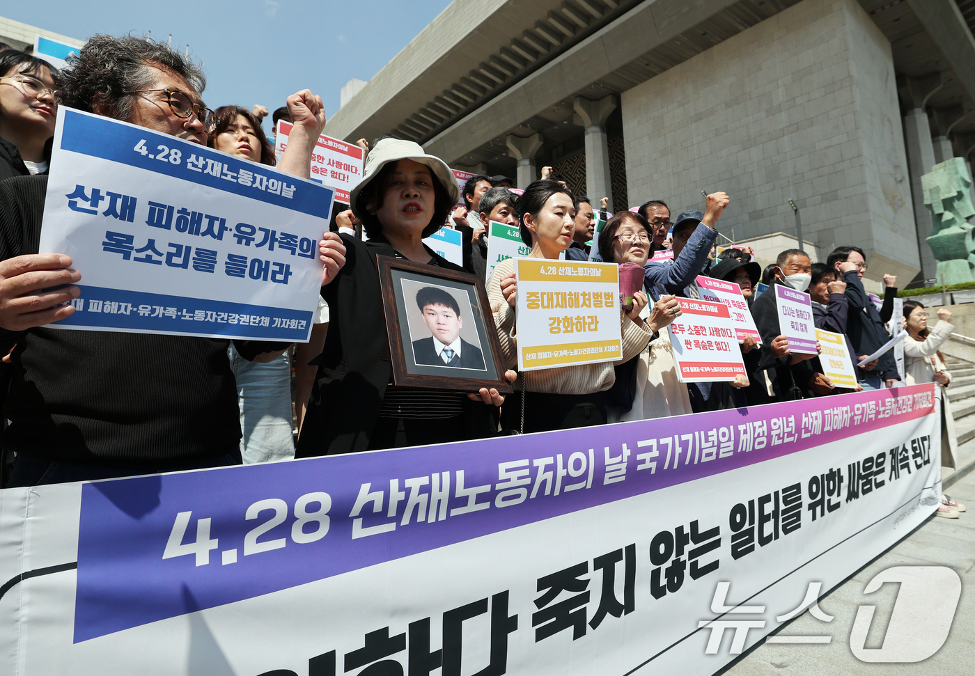 (서울=뉴스1) 오대일 기자 = 28일 서울 종로구 세종문화회관 앞에서 열린  '산재 노동자의날 국가기념일 제정 원년, 산재 피해자·유가족 기자회견'에서 산재 피해자 유가족들이 구 …