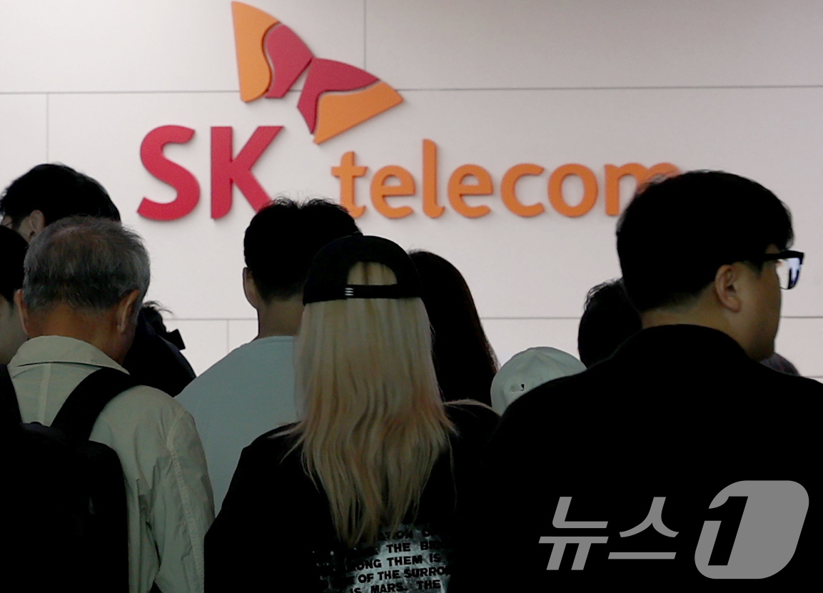 (인천공항=뉴스1) 권현진 기자 = 해킹 공격으로 가입자 유심 정보가 탈취된 SK텔레콤이 가입자 유심 무상 교체를 시작한 28일 오전 인천공항 제2터미널 SKT매장 앞에 고객들이 …