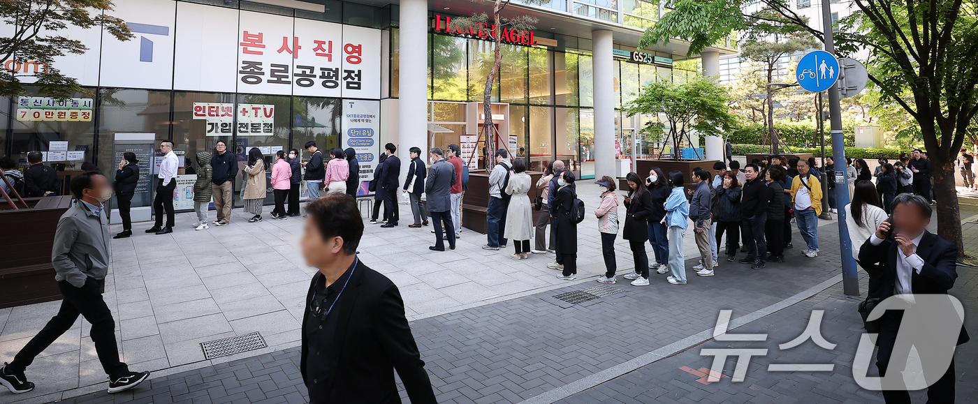 (서울=뉴스1) 김진환 기자 = SK텔레콤 가입자 유심(USIM) 정보 해킹 사고 관련 유심 무료교체 서비스 이틀 째인 29일 오전 서울 종로구 T월드 직영 매장 앞에 고객들이 줄 …