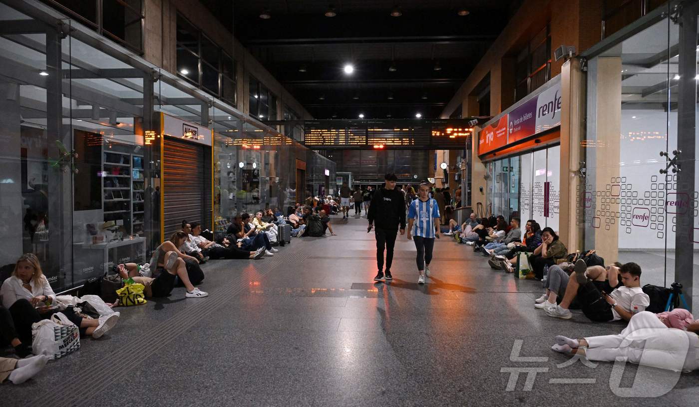(코르도바 AFP=뉴스1) 우동명 기자 = 28일(현지시간) 대규모 정전 사태가 발생한 스페인의 코르도바에서 여행객들이 기차 역서 잠을 자고 있다. 2025.04.29ⓒ AFP=뉴 …