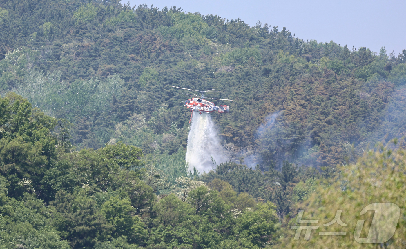 (대구=뉴스1) 김도우 기자 = 대구 북구 함지산 산불 이틀째인 29일 오후 산불 진화 작전에 투입된 산림청 산불 진화용 헬기가 함지산 상공에서 물을 뿌리고 있다. 2025.4.2 …