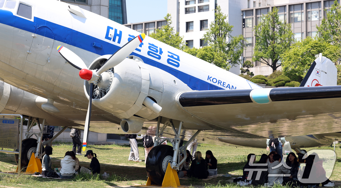 (인천=뉴스1) 김명섭 기자 = 29일 인천광역시 미추홀구 인하대학교에서 학생들이 따가운 봄 햇살을 피해 비행기 그늘 아래에서 피크닉을 즐기고 있다.이 항공기는 1954년 도입된 …