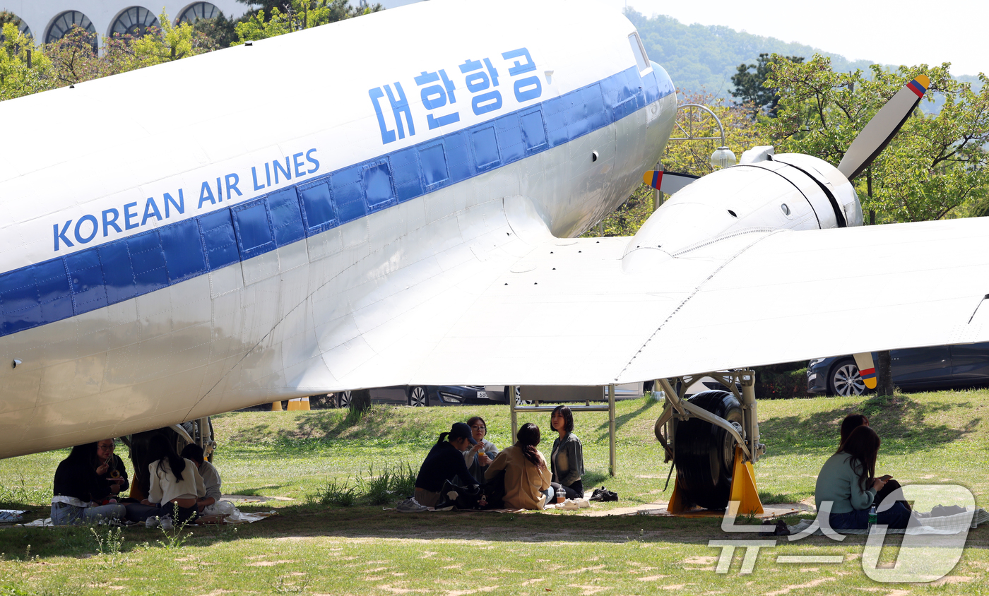 (인천=뉴스1) 김명섭 기자 = 29일 인천광역시 미추홀구 인하대학교에서 학생들이 따가운 봄 햇살을 피해 비행기 그늘 아래에서 피크닉을 즐기고 있다.이 항공기는 1954년 도입된 …