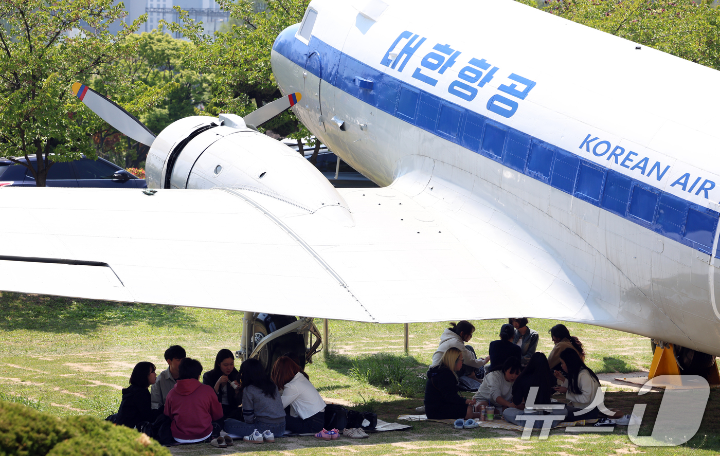 (인천=뉴스1) 김명섭 기자 = 29일 인천광역시 미추홀구 인하대학교에서 학생들이 따가운 봄 햇살을 피해 비행기 그늘 아래에서 피크닉을 즐기고 있다.이 항공기는 1954년 도입된 …