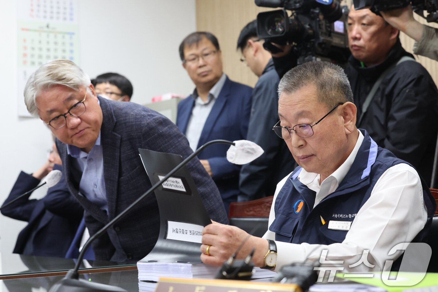 본문 이미지 - 박점곤 서울시버스노동조합 위원장이 29일 서울 영등포구 서울지방노동위원회에서 열린 사측 서울시버스운송조합과의 임금·단체협약&#40;임단협&#41; 막판 협상에 앞서 조정신청서 서류를 살펴보고 있다. 왼쪽은 김정환 서울시버스운송조합 이사장. &#40;공동취재&#41; 2025.4.29/뉴스1 ⓒ News1 이승배 기자