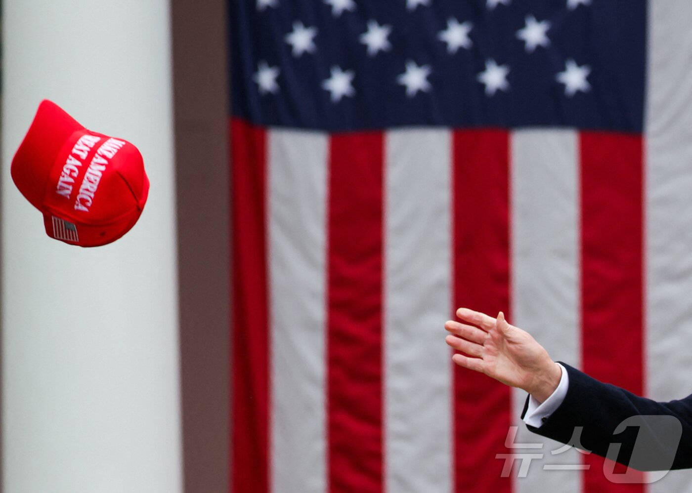 본문 이미지 - 도널드 트럼프 미국 대통령이 2일(현지시간) 미국 워싱턴 DC 백악관 로즈가든에서 관세에 대한 연설을 하던 중' MAGA' 모자를 잡으려고 하고 있다. ⓒ 로이터=뉴스1