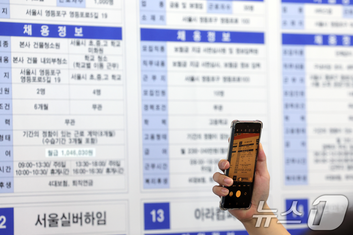 (서울=뉴스1) 박정호 기자 = 30일 오후 서울 영등포구 국회대로 영등포아트홀에서 열린 2025 희망‧행복·미래 취업박람회를 찾은 구직자가 채용게시대에서 관심 기업을 촬영하고 있 …