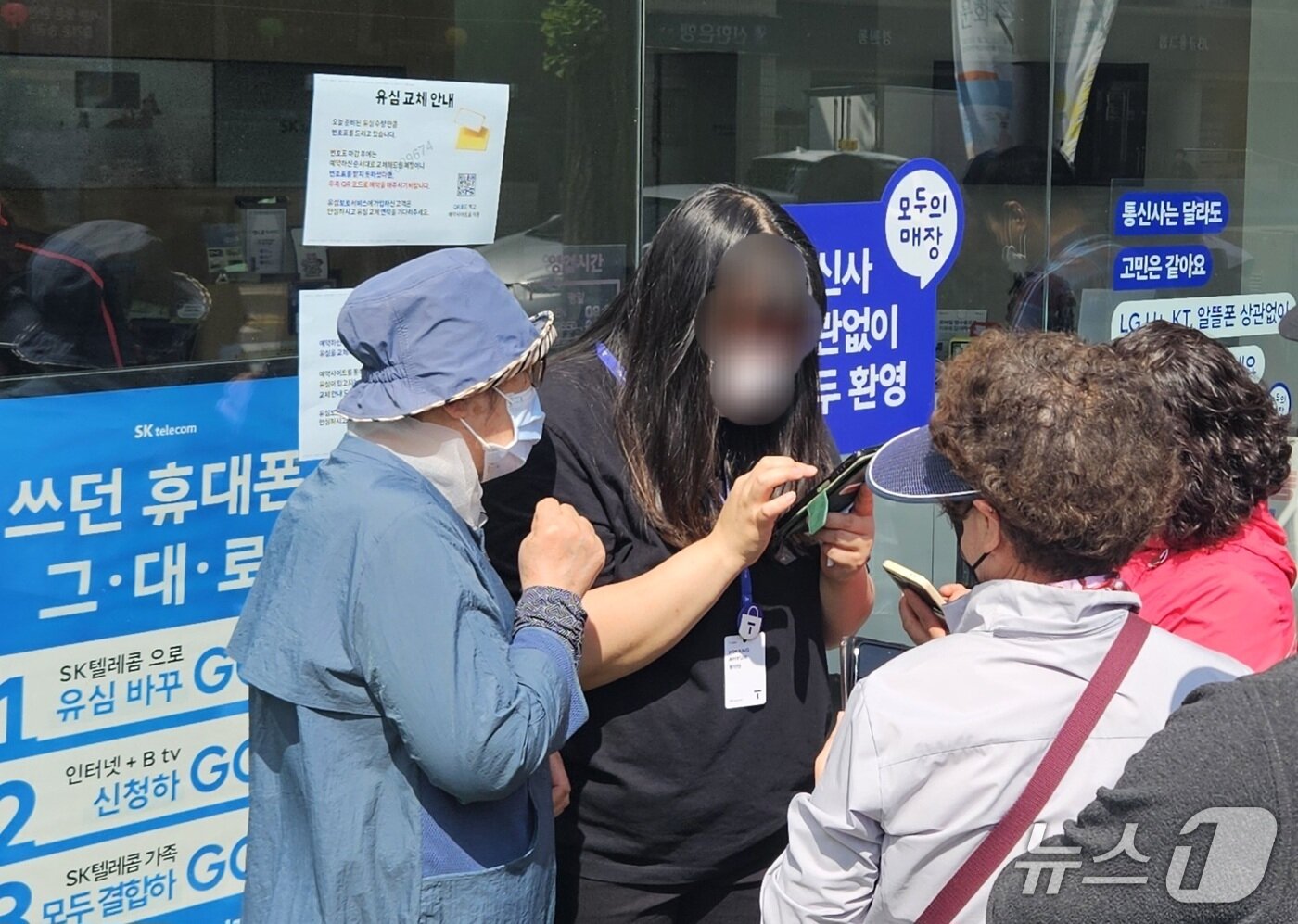 본문 이미지 -  전북자치도 전주시의 한 SK텔레콤 대리점 직원이 유심 무상 교체 온라인 예약 방법을 안내하고 있다. 뉴스1/ 신준수 기자