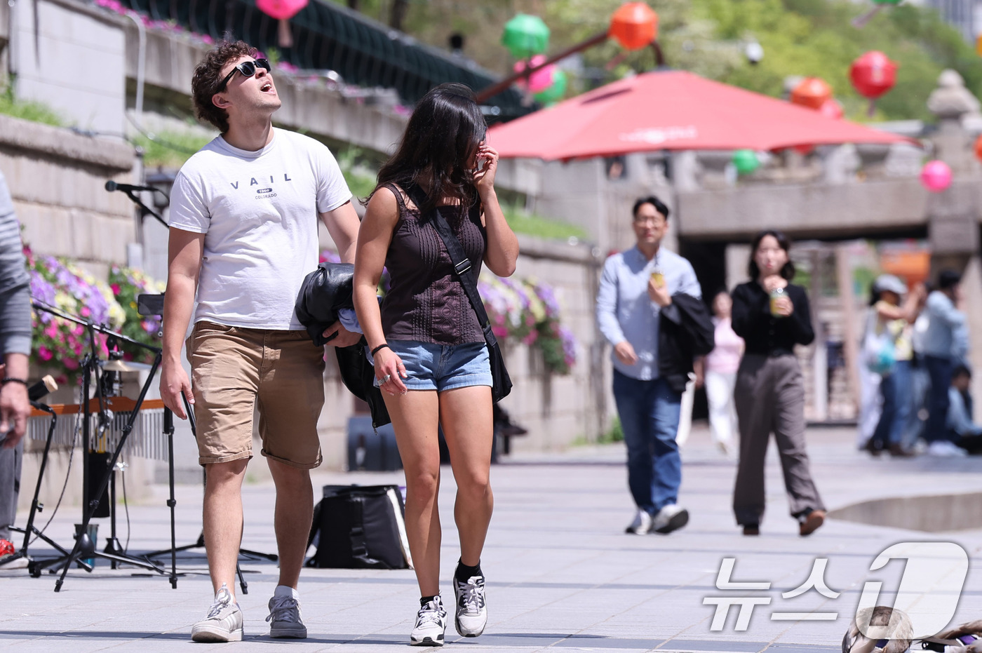 (서울=뉴스1) 박지혜 기자 = 초여름에 가까운 날씨를 보인 30일 오후 서울 청계천을 찾은 외국인 관광객이 겉옷을 든 채 이동하고 있다. 2025.4.30/뉴스1