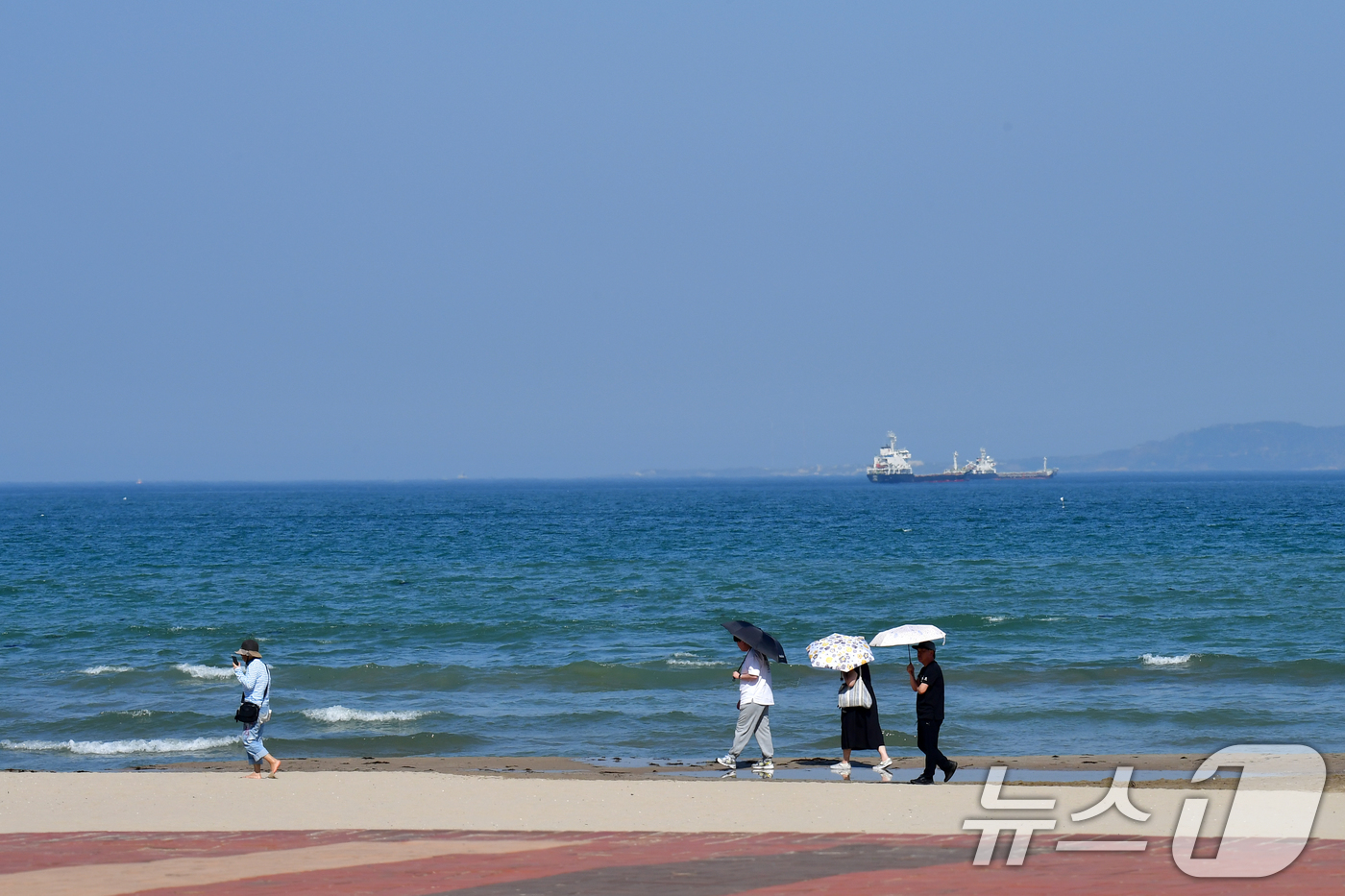 (포항=뉴스1) 최창호 기자 = 30일 오후 경북 포항시의 낮 최고 기온이 29.3도까지 올라가며 초여름 날씨를 보인 가운데 영일대해수욕장 백사장에서 양산을 쓴 관광객들이 걸어가고 …
