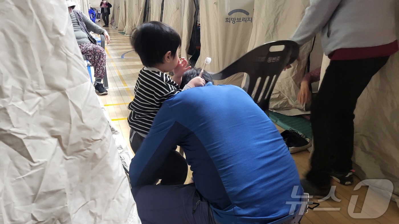 (대구=뉴스1) 이성덕 기자 = 30일 오후 9시30분 대구 북구 동변중에 마련된 대피소에서 아이가 \"집에 가고 싶다\"며 칭얼대고 있다. 지난 28일 오후 2시2분 함지산에서 …