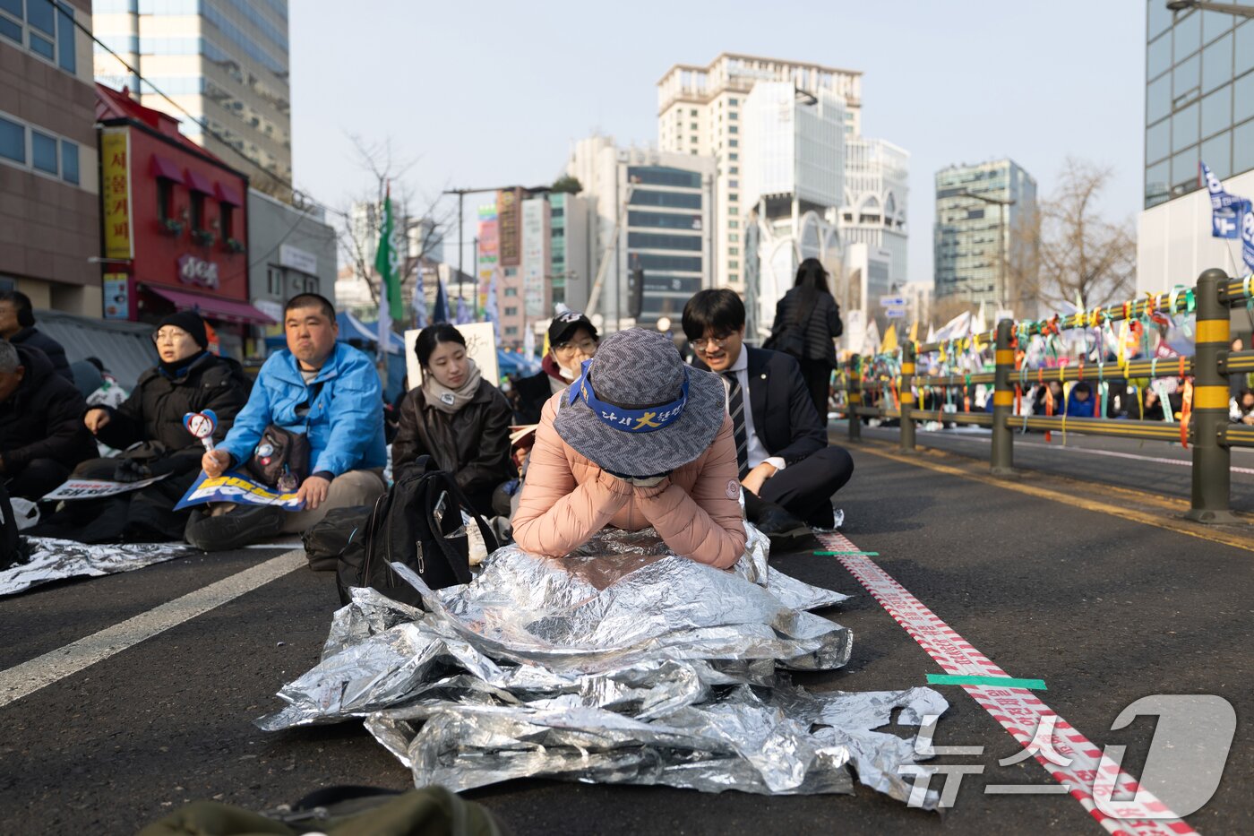 본문 이미지 - 윤석열 대통령 탄핵 선고일인 4일 서울 종로구 안국역 인근에서 윤 대통령의 탄핵을 촉구하며 밤을 지샌 한 시민이 얼굴을 감싸쥐고 있다. 2025.4.4/뉴스1 ⓒ News1 이승배 기자