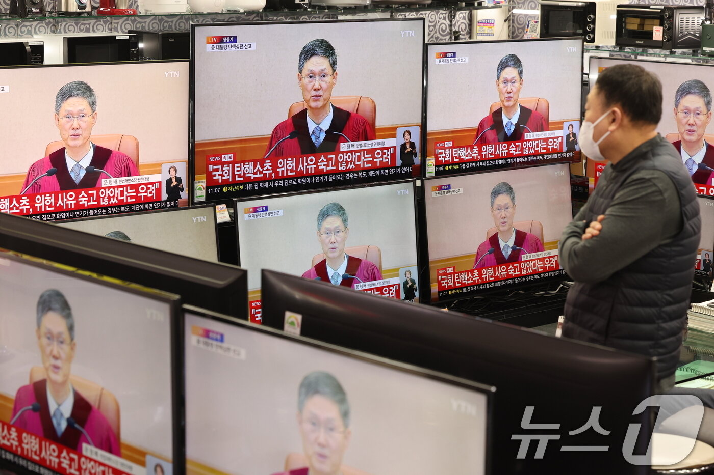 본문 이미지 - 4일 오전 서울 용산구 전자랜드 가정매장에서 한 시민이 윤석열 대통령의 탄핵심판 선고 TV 생중계를 지켜보고 있다. 2025.4.4/뉴스1 ⓒ News1 이동해 기자