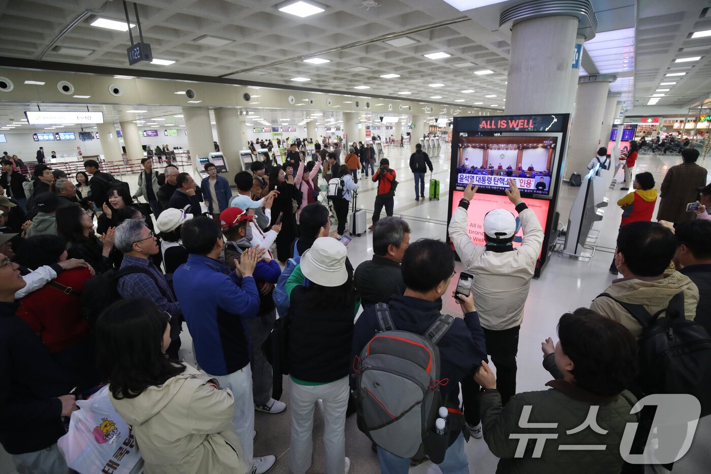 본문 이미지 - 4일 오전 제주국제공항 국내선 출발장에서 탄핵 심판 생중계를 지켜보는 관광객과 도민들이 윤석열 대통령의 탄핵심판이 인용되자 환호하고 있다. 2025.4.4/뉴스1 ⓒ News1 오현지 기자