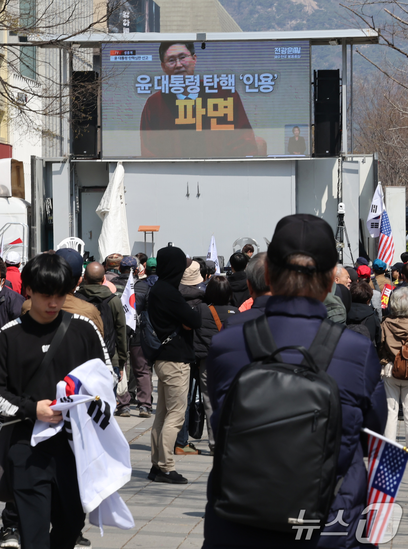 (서울=뉴스1) 장수영 기자 = 윤석열 대통령 탄핵심판 선고일인 4일 서울 중구 세종대로사거리에서 탄핵 반대 집회 참석자들이 헌법재판소의 대통령 파면 인용 생중계를 시청하고 있다. …