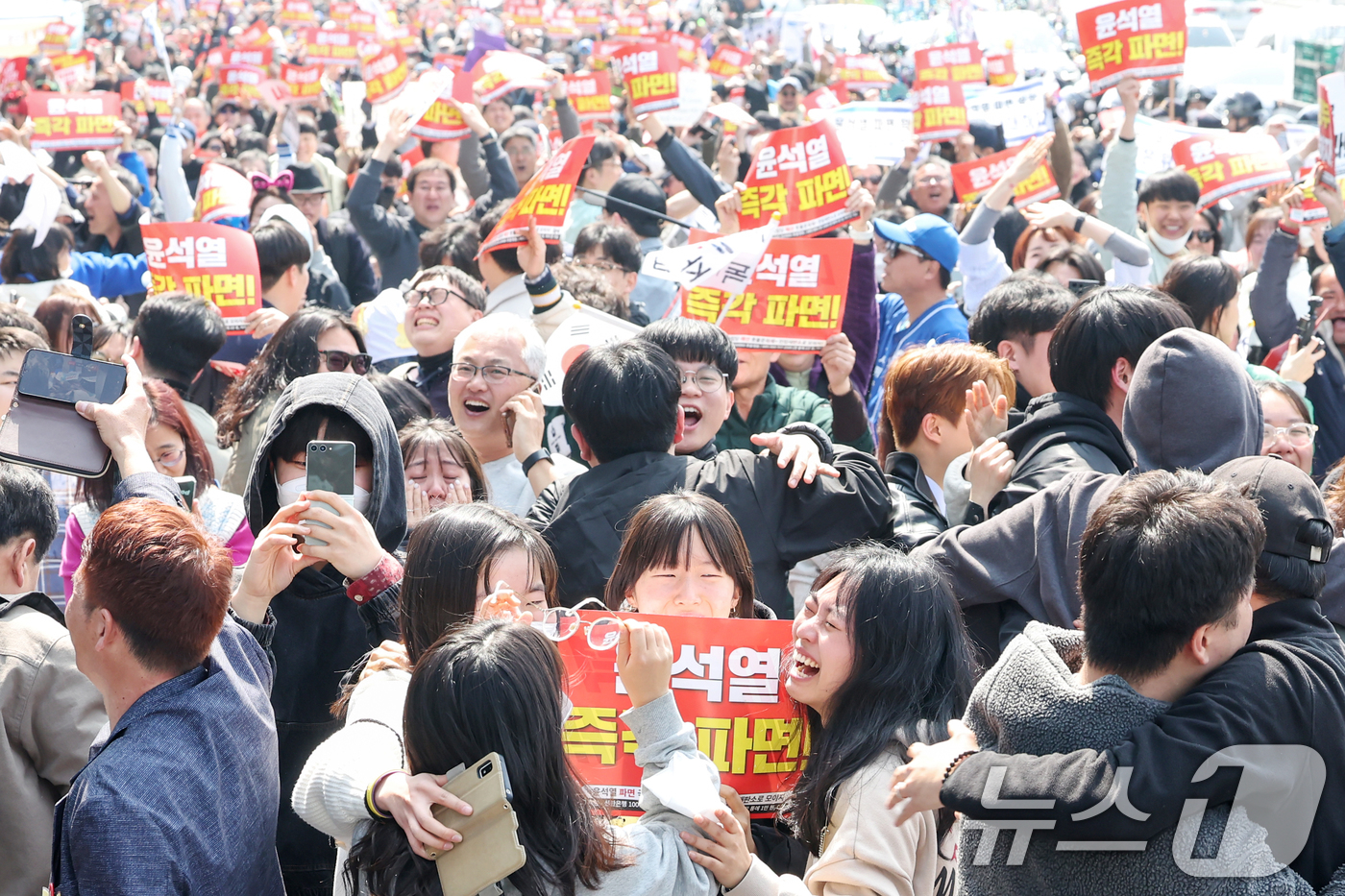 (서울=뉴스1) 민경석 기자 = 4일 오전 서울 용산구 대통령 관저 앞 도로에서 진보단체 회원들을 비롯한 시민들이 헌재의 윤석열 대통령에 대한 탄핵 선고 소식에 기뻐하고 있다. 2 …