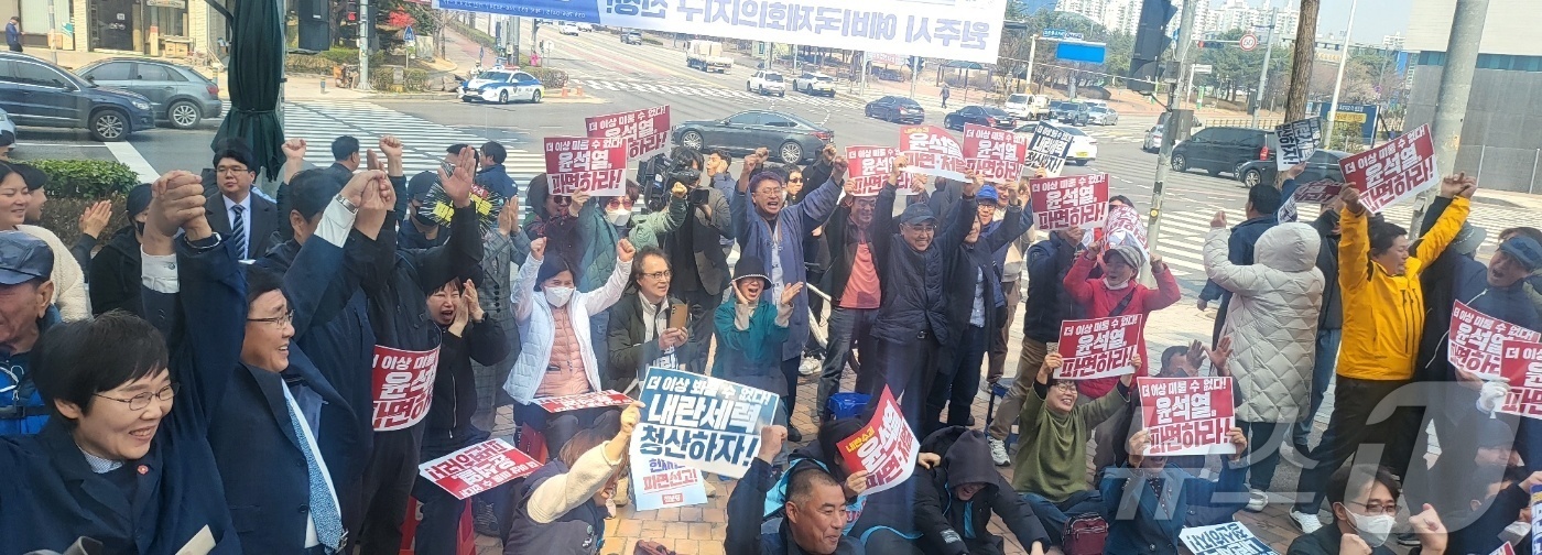 (원주=뉴스1) 신관호 기자 = 윤석열 대통령 탄핵심판 선고일인 4일 강원 원주의료원 사거리에서 헌재의 선고를 생중계로 지켜본 시민들이  환호하고 있다. 2025.4.4./뉴스1