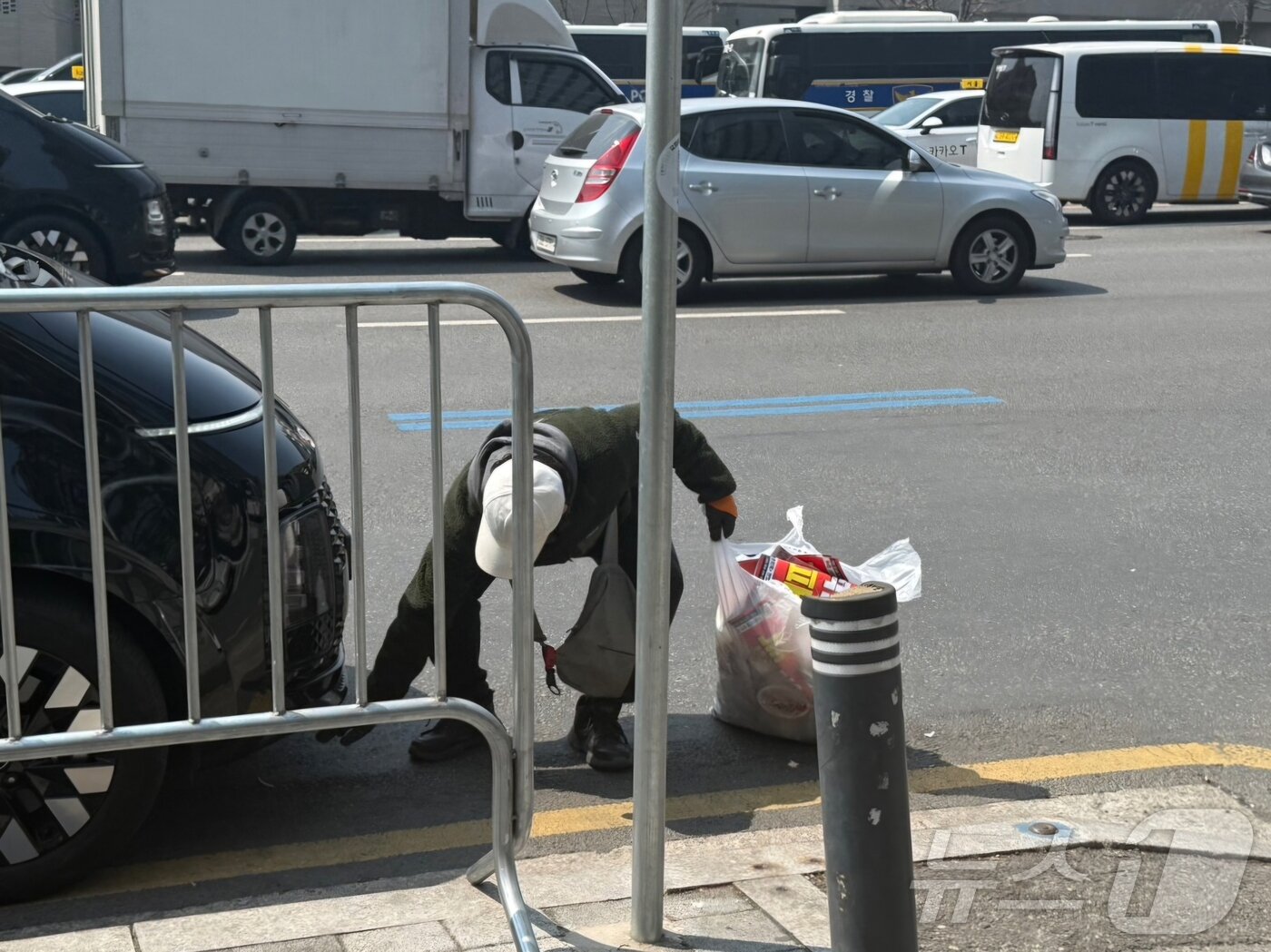 본문 이미지 - 4일 탄핵 집회 참가자가 바닥에 떨어진 쓰레기를 줍고 있다. 2025.4.4/뉴스1 ⓒ News1 김형준 기자