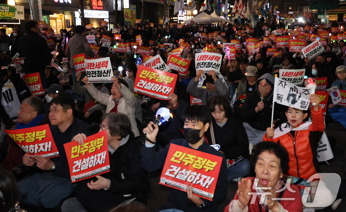 (서울=뉴스1) 장수영 기자 = 4일 저녁 서울 중구 시청역 인근에서 열린 촛불행동 집회 참석자들이 헌법재판소의 윤석열 전 대통령 탄핵 인용을 자축하는 문화제를 하고 있다. 202 …