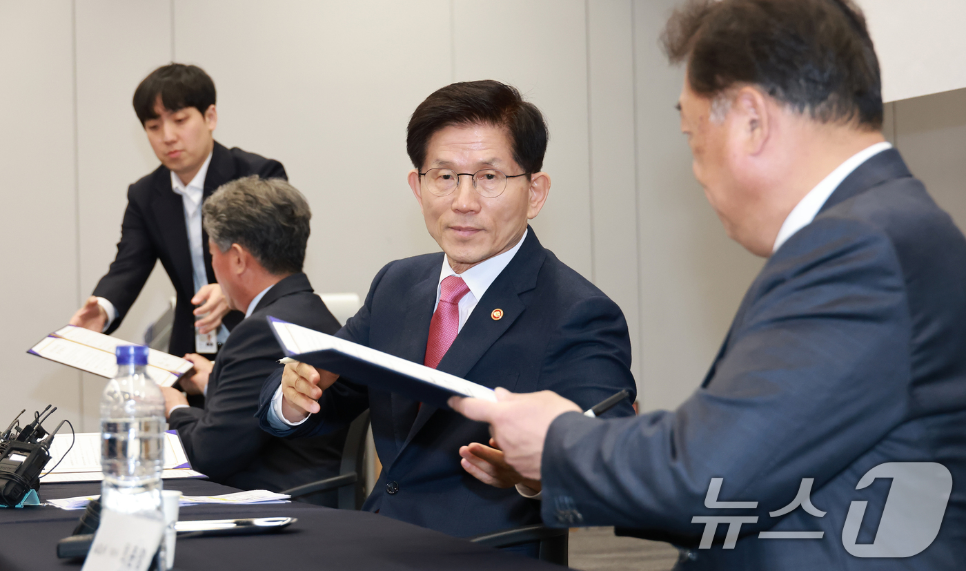 (서울=뉴스1) = 김문수 고용노동부 장관이 7일 경기도 용인시 '기아 오산교육센터'에서 열린 '고용노동부·기아·오토큐 전기차 정비인력 양성을 위한 MOU'에서 업무협약 서류를 전 …