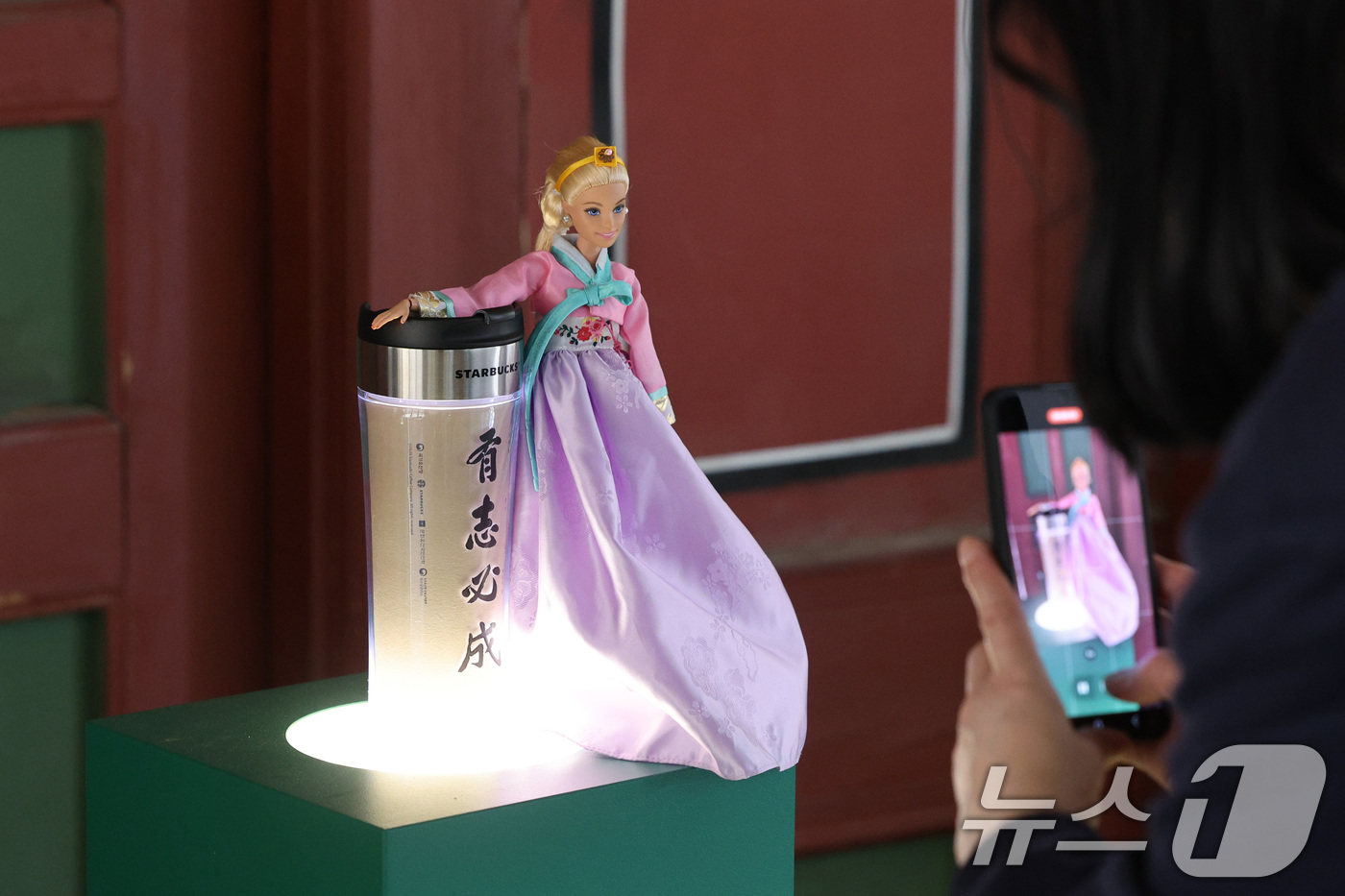 (서울=뉴스1) 신웅수 기자 = 8일 서울 덕수궁 덕홍전에서 열린 '유묵(遺墨), 별이 되어 빛나다. 두 번째 빛' 전시회에서 한 관람객이 독립운동가의 친필 붓글씨가 담긴 텀블러와 …