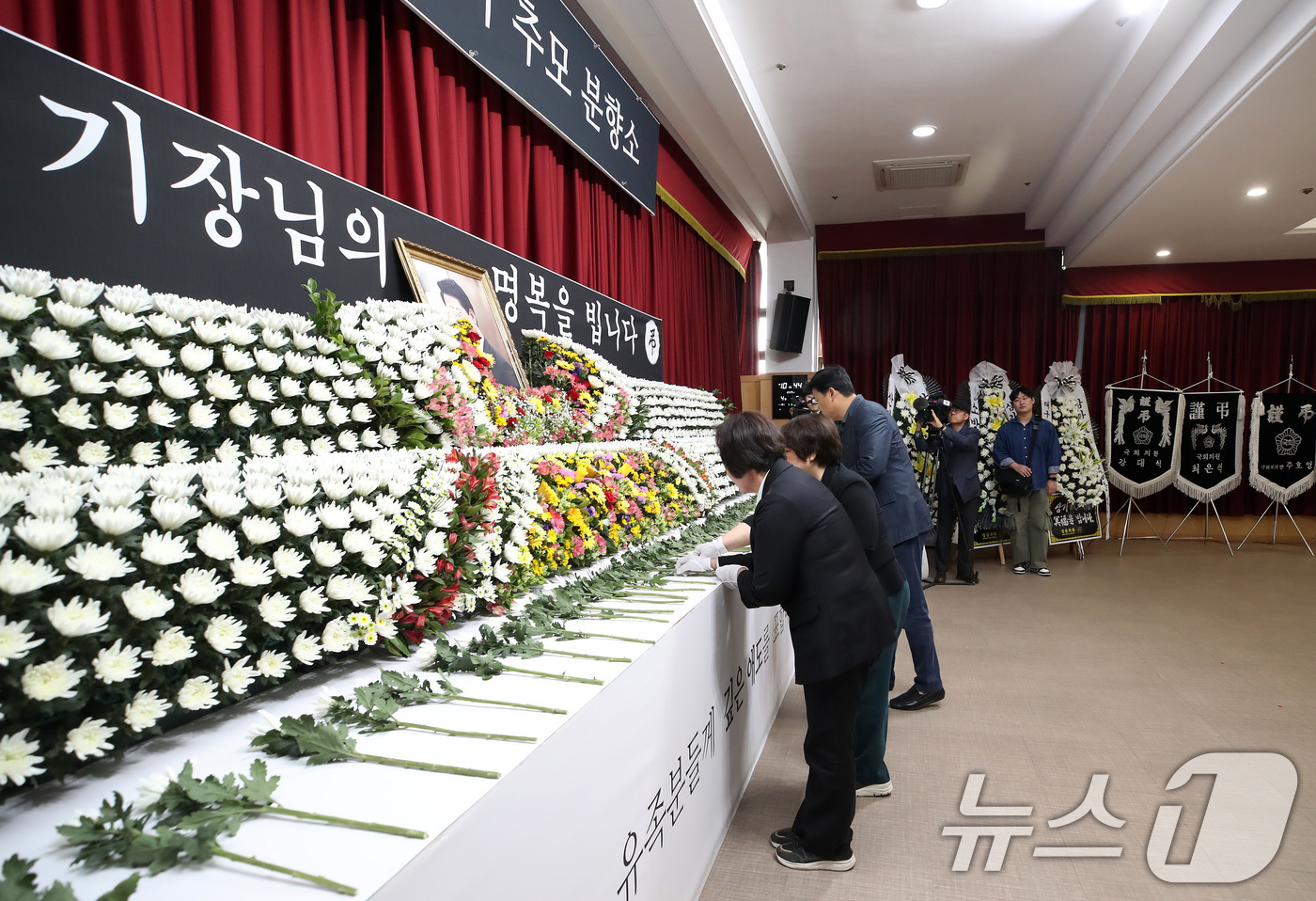 (대구=뉴스1) 공정식 기자 = 9일 대구 동구청 대회의실에 마련된 산불 진화 헬기 조종사 故 정궁호 기장의 추모 분향소를 찾은 시민들이 헌화하며 명복을 빌고 있다. 2025.4. …
