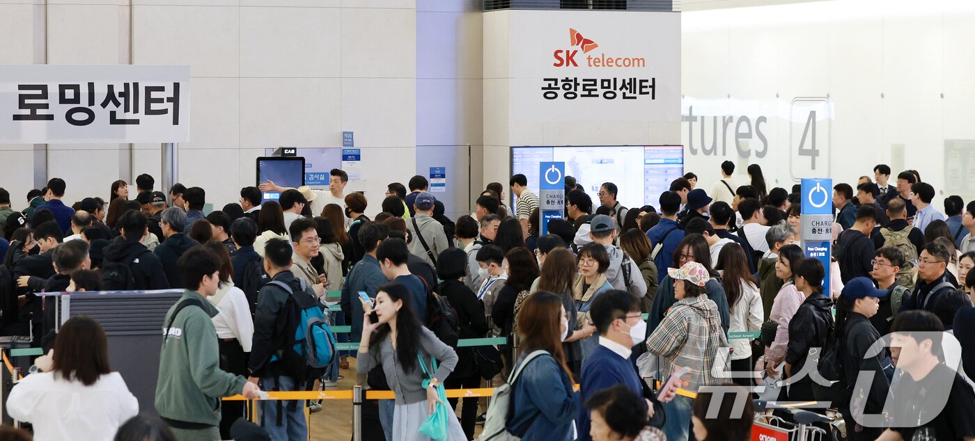 본문 이미지 - 최장 엿새간 이어지는 징검다리 황금연휴가 시작된 1일 인천국제공항 제1여객터미널 SK텔레콤 로밍센터에서 여행객들이 유심 교체를 위해 대기하고 있다. 2025.5.1/뉴스1 ⓒ News1 김진환 기자
