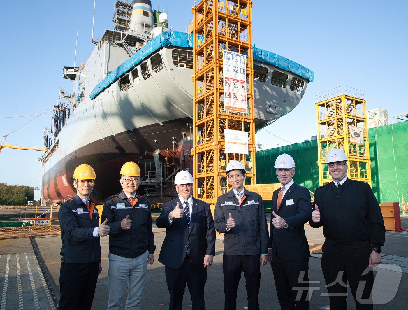 본문 이미지 - 김동관 한화그룹 부회장이 30일 오후 한화오션 거제사업장을 방문한 존 필린(John C. Phelan) 미국 해군성 장관(왼쪽 세 번째)과 거제사업장에서 MRO(Maintenance, Repair and Overhaul, 유지·보수·정비) 중인 미국 해군 7함대의 급유함인 ‘유콘’함을 배경으로 기념 촬영을 하고 있다. (한화오션 제공. 재판매 및 DB 금지) 2025.5.1/뉴스1