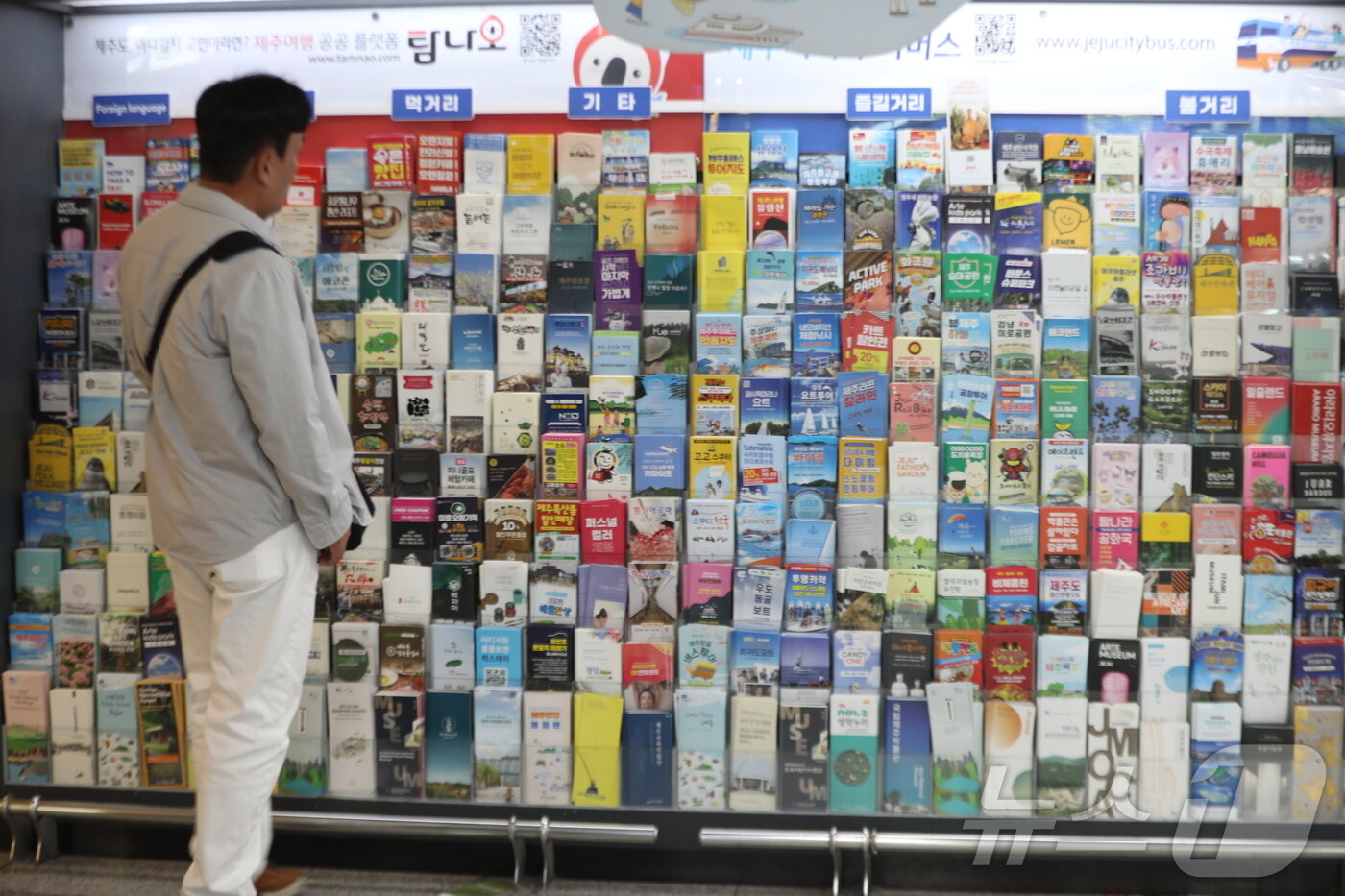 본문 이미지 - 근로자의 날과 어린이날, 대체공휴일까지 이어지는 황금연휴 첫날인 1일 제주국제공항에 도착한 관광객이 진열대에 진열된 제주관광지 홍보물을 살펴보고 있다. 2025.5.1/뉴스1 ⓒ News1 강승남 기자