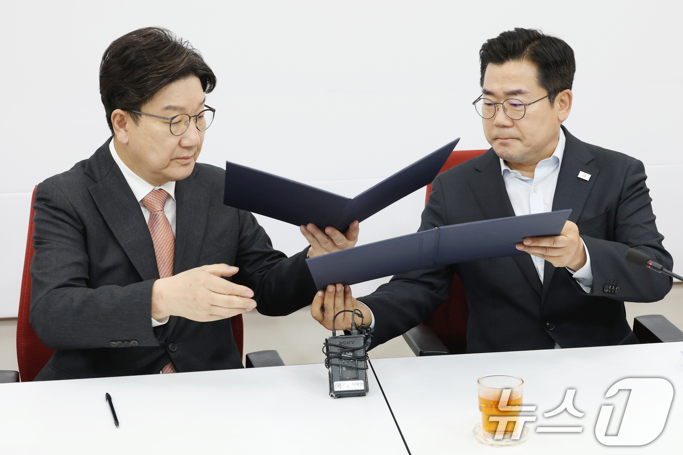 (서울=뉴스1) 이광호 기자 = 권성동 국민의힘 원내대표와 박찬대 더불어민주당 원내대표가 1일 오전 서울 여의도 국회에서 서명한 추경안 합의문을 교환하고 있다. 2025.5.1/뉴 …