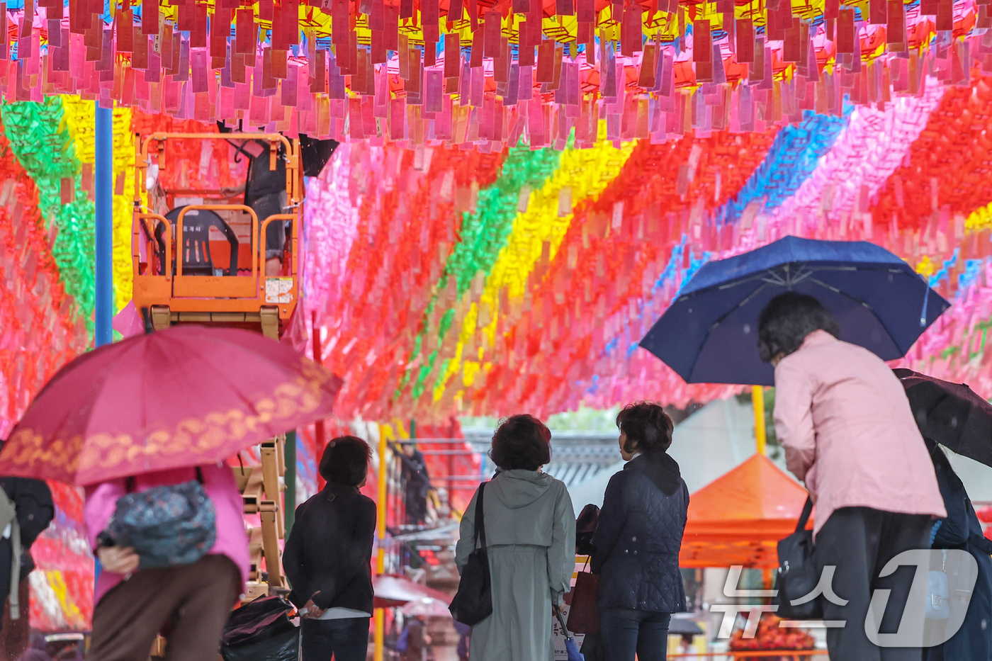 (서울=뉴스1) 민경석 기자 = 서울을 비롯한 수도권 일대에 비가 내린 1일 서울 종로구 조계사 일주문 아래에서 불자들이 비를 피하며 연등을 바라보고 있다. 2025.5.1/뉴스1 …
