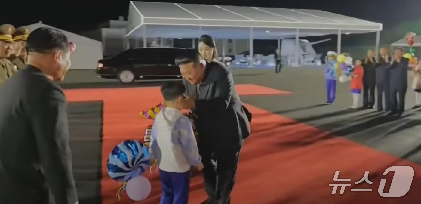 본문 이미지 - 지난달 25일 열린 5000t급 신형 구축함 &#39;최현호&#39; 진수 기념식에서 김정은 총비서가 어린 아이의 볼을 맞잡고 있다 &#40;조선중앙tv 화면 갈무리&#41;