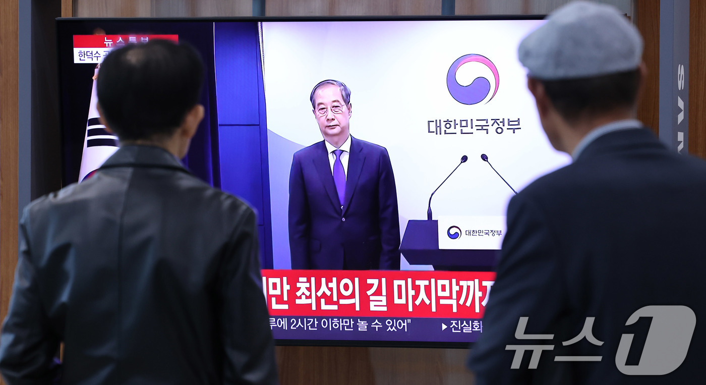 (서울=뉴스1) 박지혜 기자 = 시민들이 1일 오후 서울역 대합실에서 한덕수 대통령 권한대행 국무총리의 대국민담화 발표 생중계 영상을 시청하고 있다.이날 한 대통령 권한대행 국무총 …