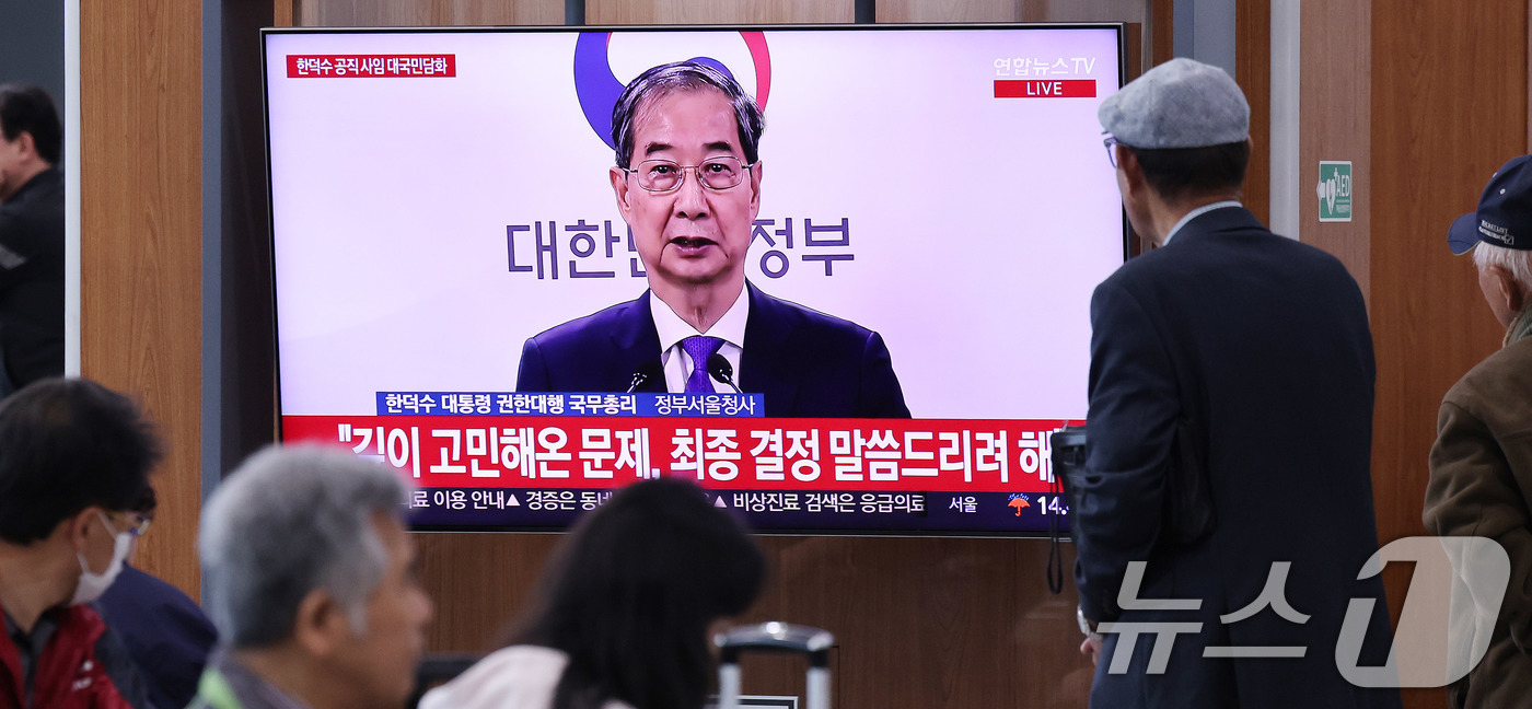 (서울=뉴스1) 박지혜 기자 = 시민들이 1일 오후 서울역 대합실에서 한덕수 대통령 권한대행 국무총리의 대국민담화 발표 생중계 영상을 시청하고 있다.이날 한 대통령 권한대행 국무총 …