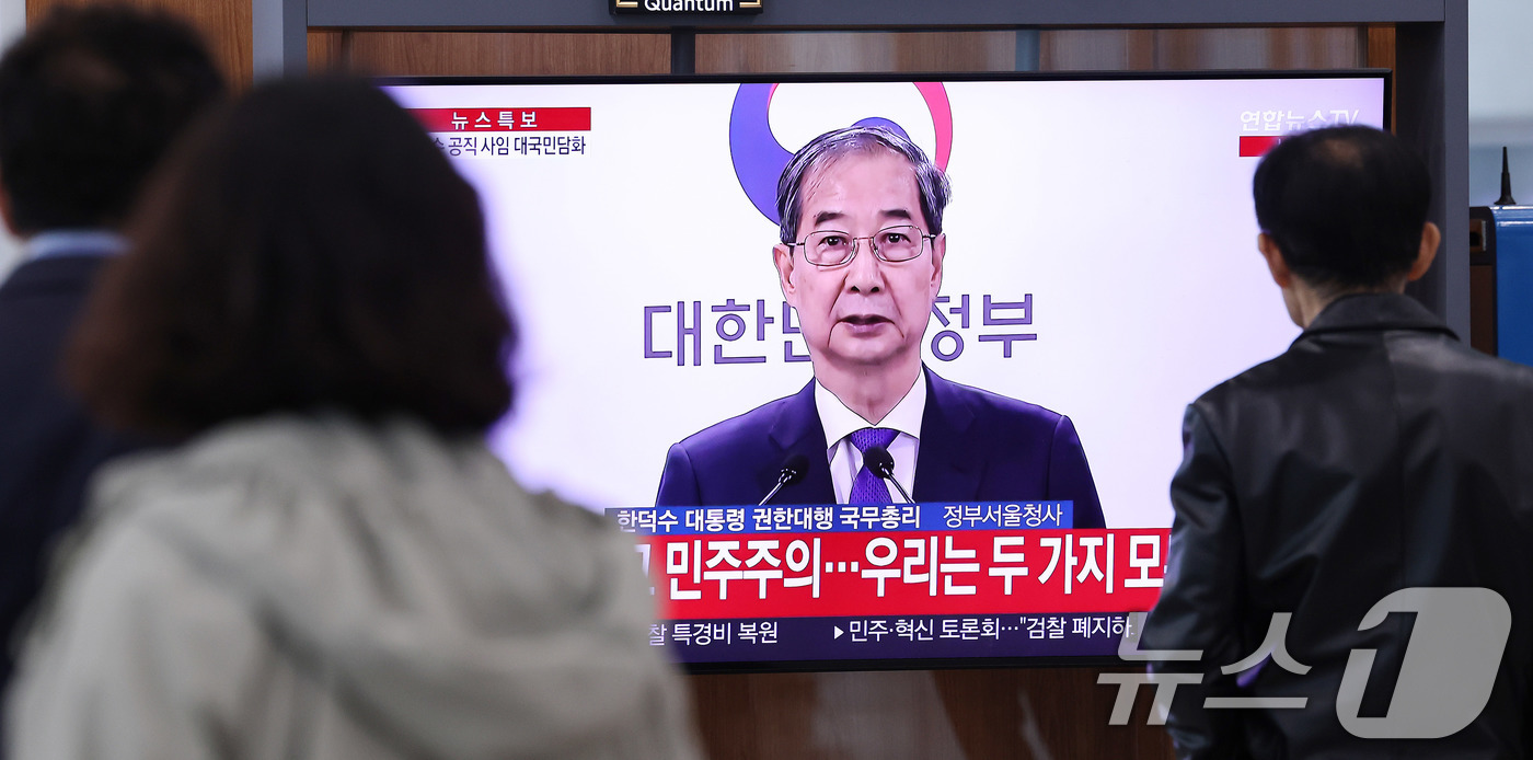 (서울=뉴스1) 박지혜 기자 = 시민들이 1일 오후 서울역 대합실에서 한덕수 대통령 권한대행 국무총리의 대국민담화 발표 생중계 영상을 시청하고 있다.이날 한 대통령 권한대행 국무총 …