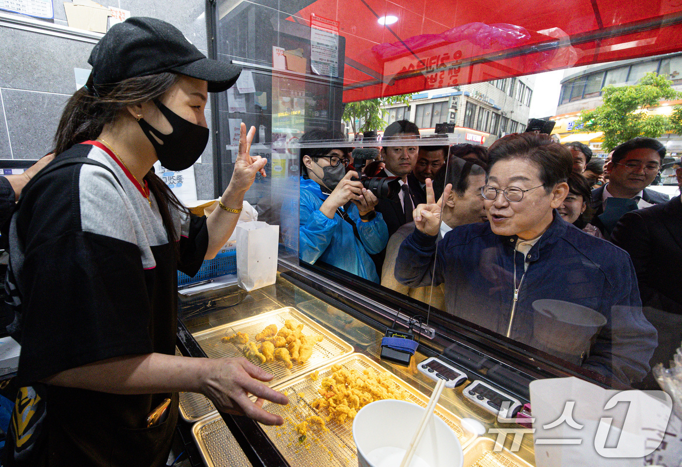 (포천=뉴스1) 이재명 기자 = 이재명 더불어민주당 대통령 후보가 1일 오후 경기도 포천시 신읍사거리 일대를 찾아 치킨집 사장과 대화를 하고 있다. 2025.5.1/뉴스1