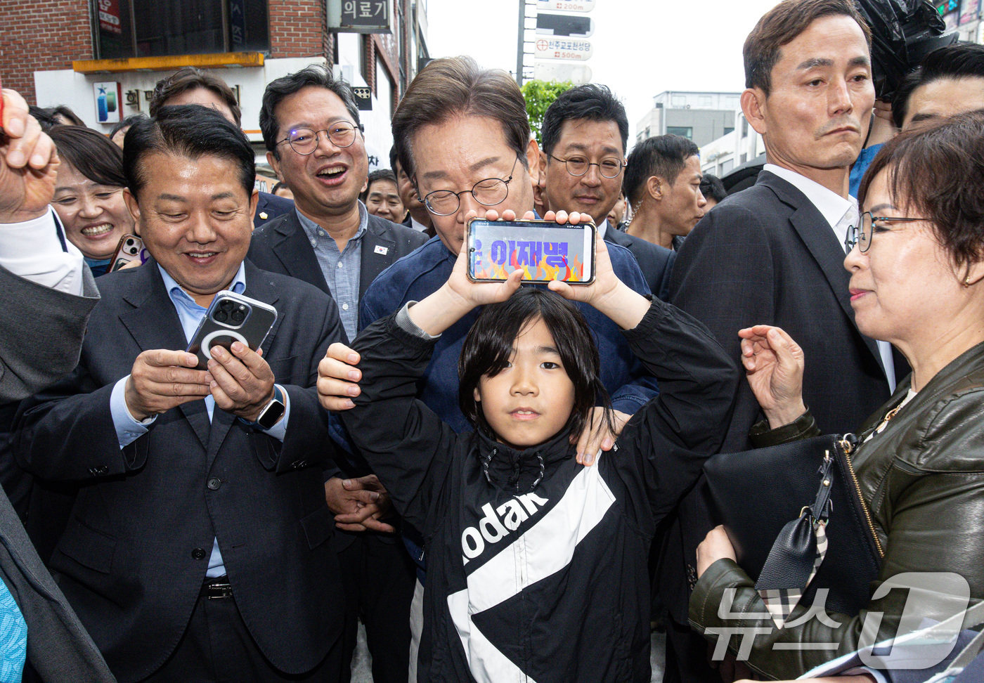 (포천=뉴스1) 이재명 기자 = 이재명 더불어민주당 대통령 후보가 1일 오후 경기도 포천시 신읍사거리 일대에서 한 어린이와 기념사진을 촬영하고 있다. 2025.5.1/뉴스1