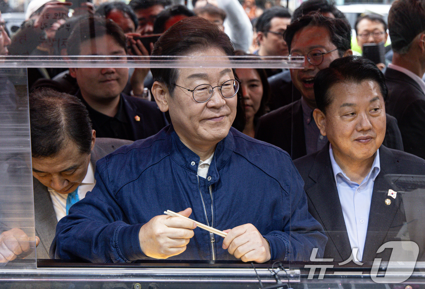 (포천=뉴스1) 이재명 기자 = 이재명 더불어민주당 대통령 후보가 1일 오후 경기도 포천시 신읍사거리 일대에서 주문한 닭강정을 기다리고 있다. 2025.5.1/뉴스1