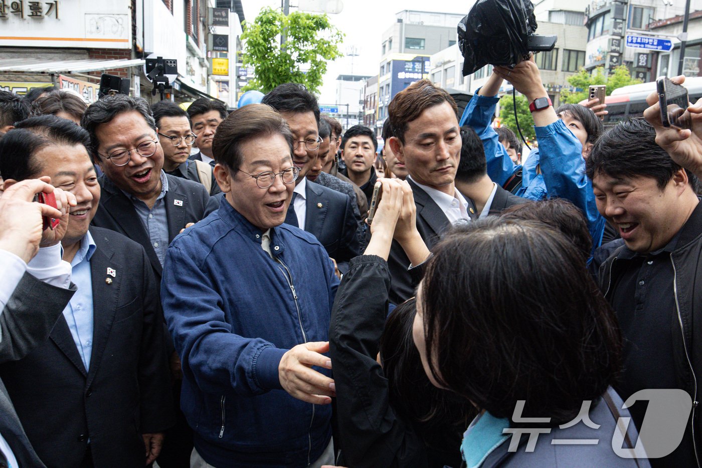 (포천=뉴스1) 이재명 기자 = 이재명 더불어민주당 대통령 후보가 1일 오후 경기도 포천시 신읍사거리 일대를 찾아 한 어린이가 스마트폰에 적은 글귀를 보고 있다. 2025.5.1/ …