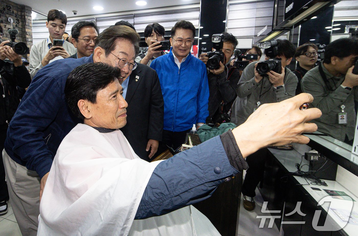 (연천=뉴스1) 이재명 기자 = 이재명 더불어민주당 대통령 후보가 1일 오후 경기도 연천군 전곡시외터미널 인근 미용실에서 한 시민과 기념사진을 촬영하고 있다. 2025.5.1/뉴스 …